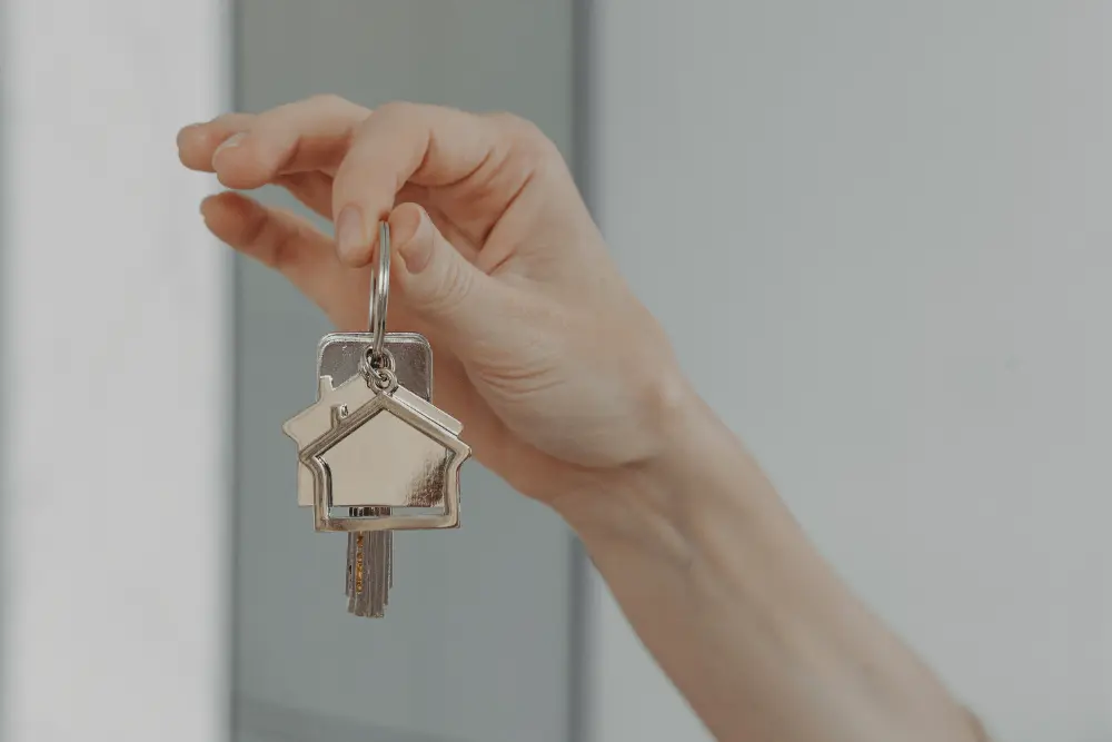 Zufriedene Kundin hält Wohnungsschlüssel nach Türöffnung in München