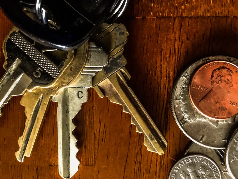 Schlüssel und Kleingeld auf einem Holztisch